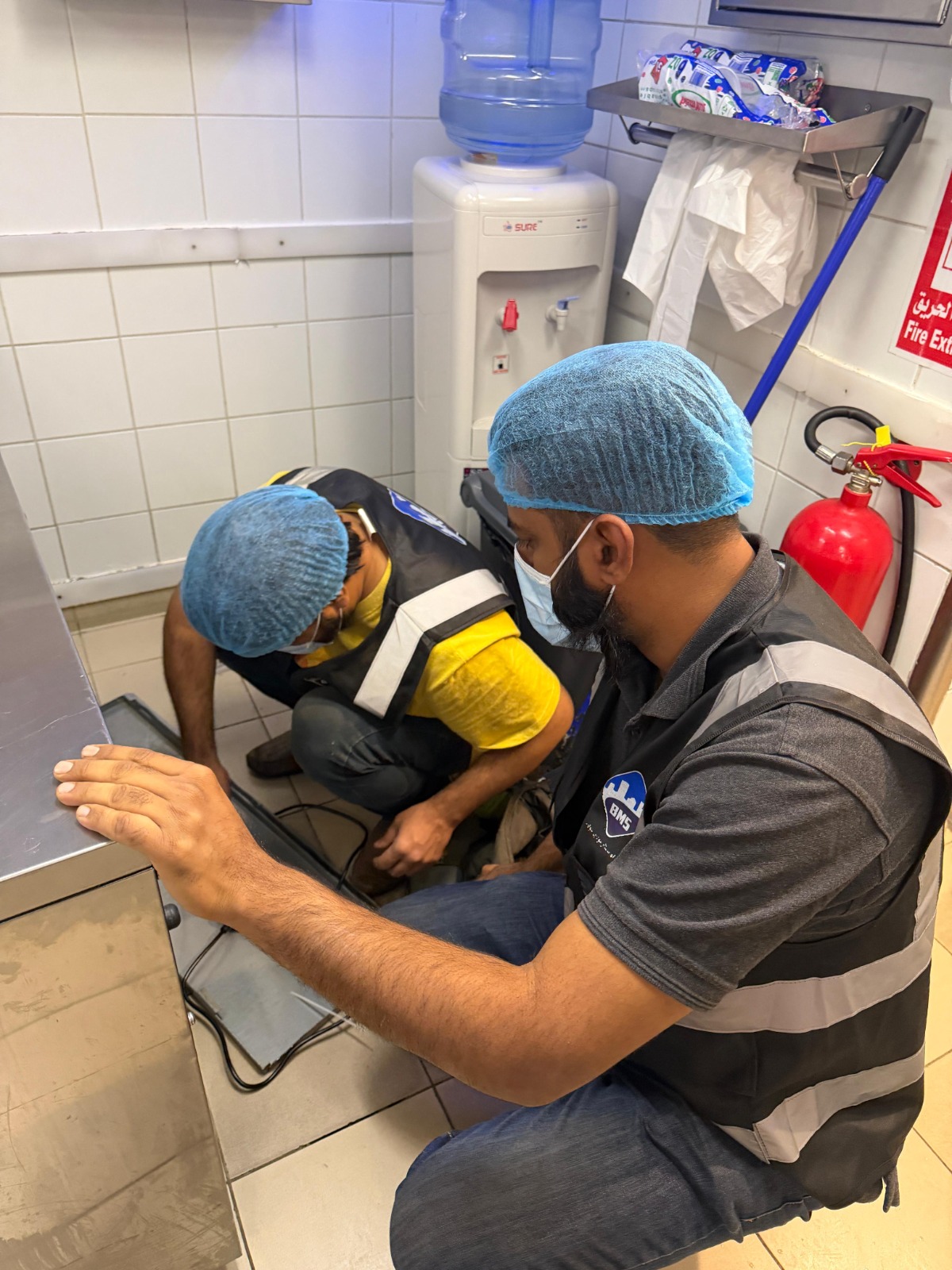Two BMS technicians carrying out a minor equipment repair on site