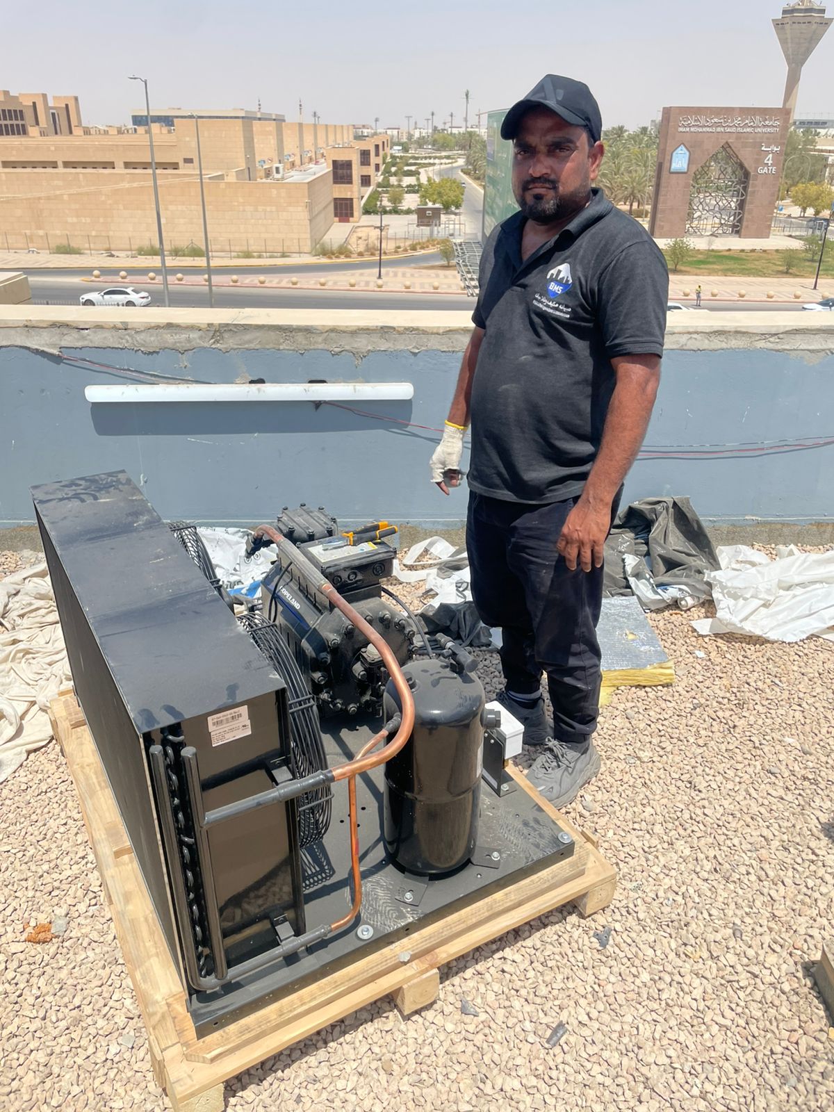 BMS technician beside a Copeland condensing unit delivered to the Nadah Plaza rooftop
