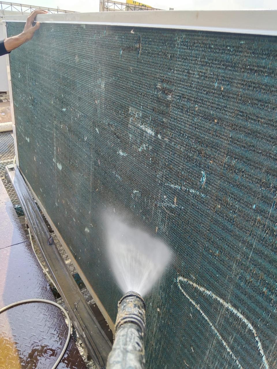 Water jet cleaning the dirt-loaded fins of a large outdoor condenser coil