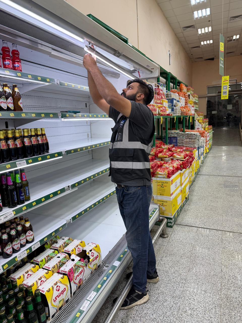 فني يركب أنبوب LED بديلاً في وحدة إنارة رف