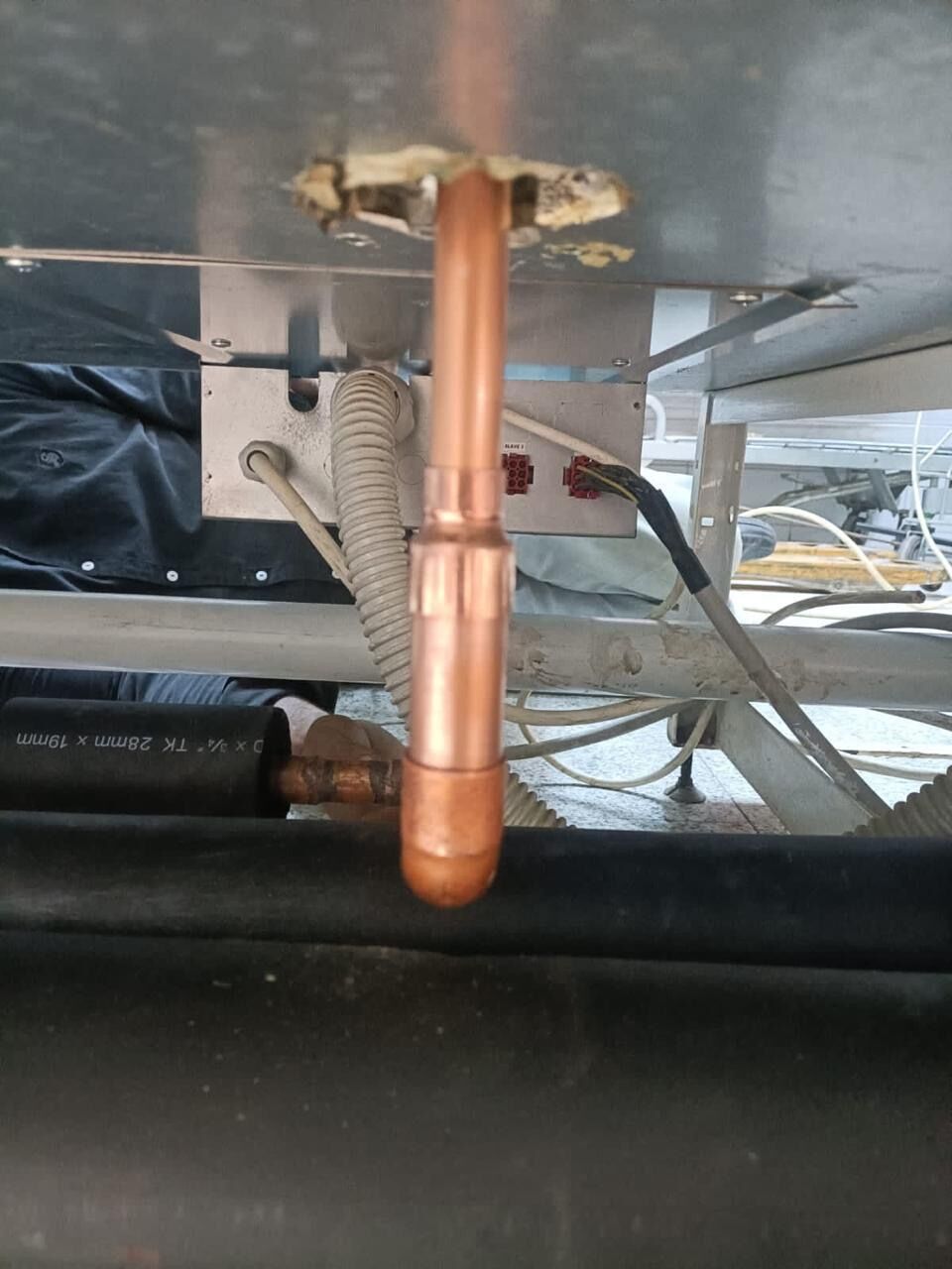Brazing a copper refrigerant riser where it passes through the deck of a display case