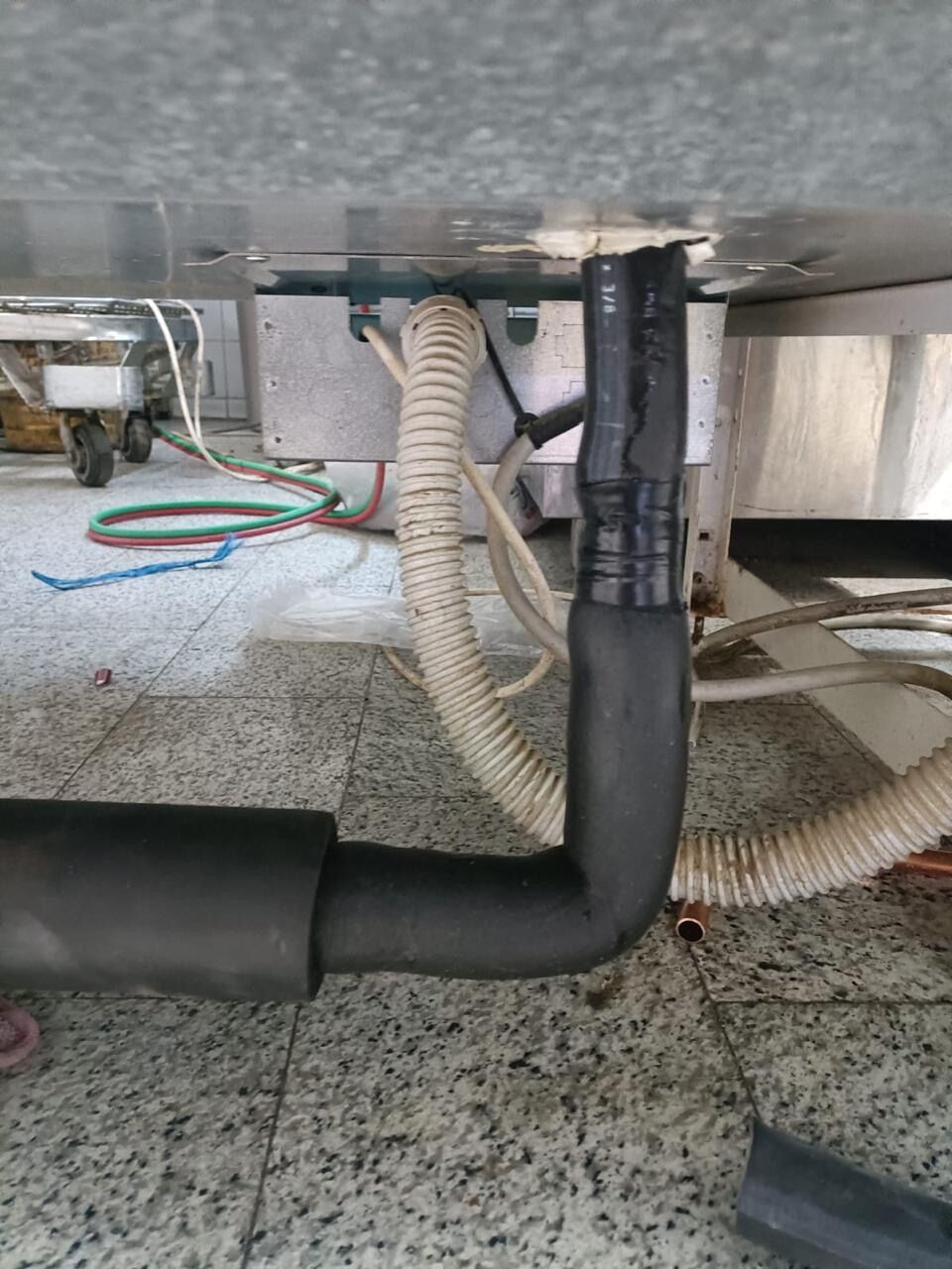 Insulated condensate and drainage pipework run beneath a display case